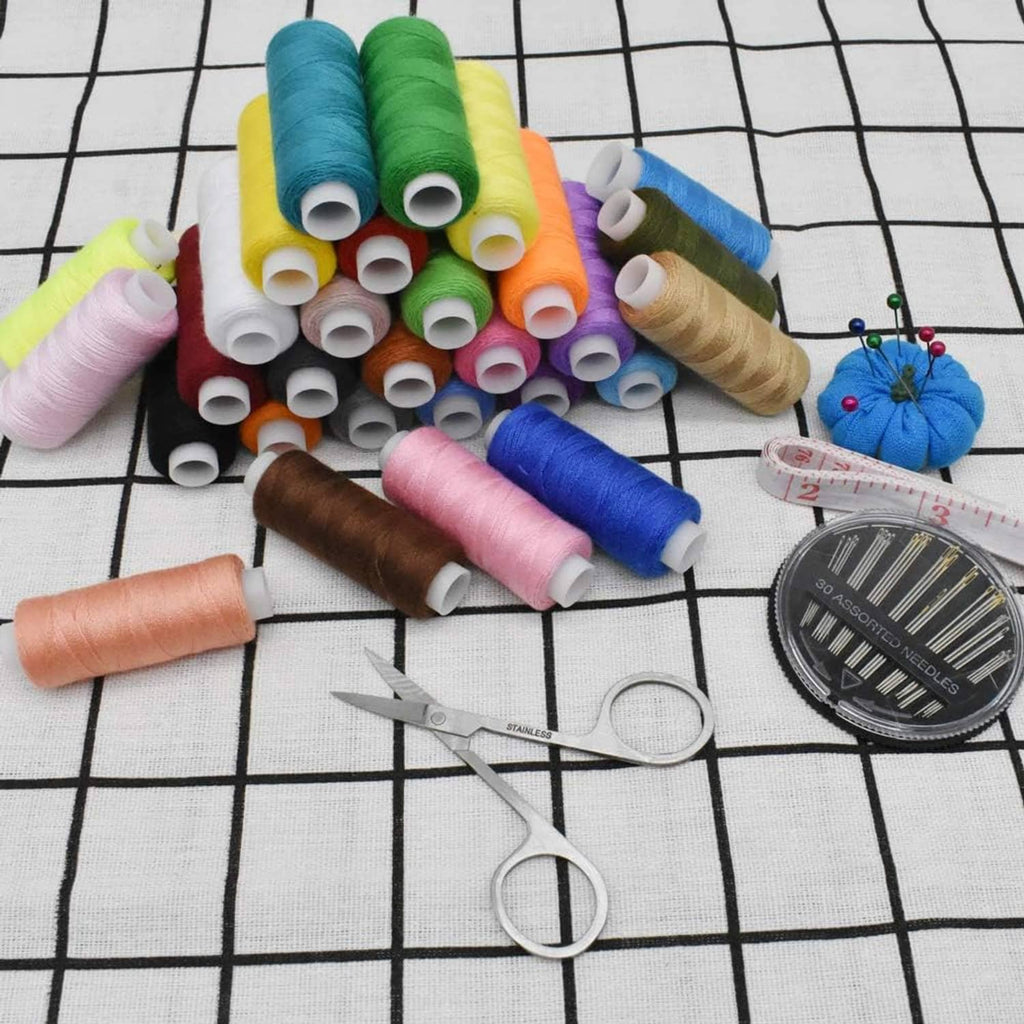 Polyester thread spools on grid fabric with measuring tape, pins, and scissors