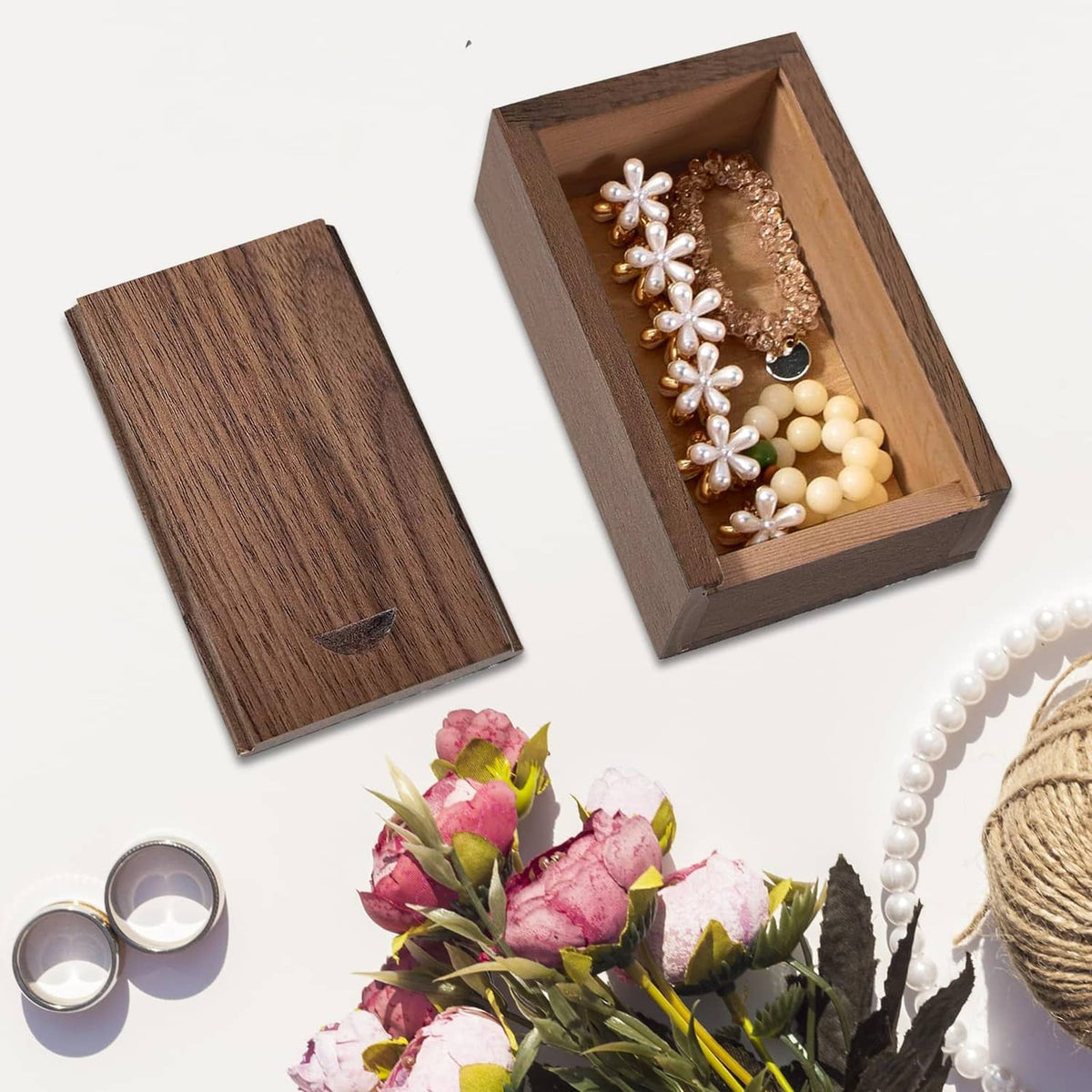 Small wooden gift box with sliding lid, open with jewelry items inside