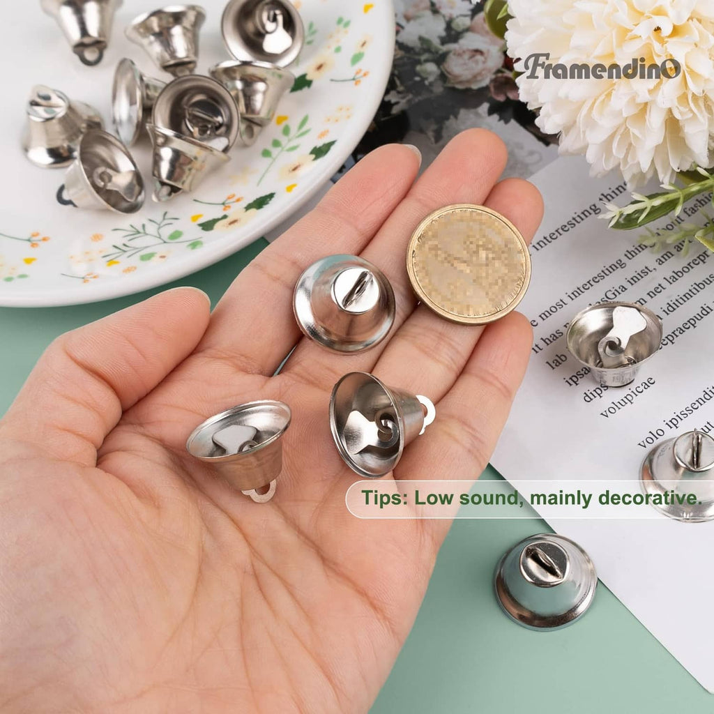 Silver mini jingle bell with loop hook shown in hand, small decorative size