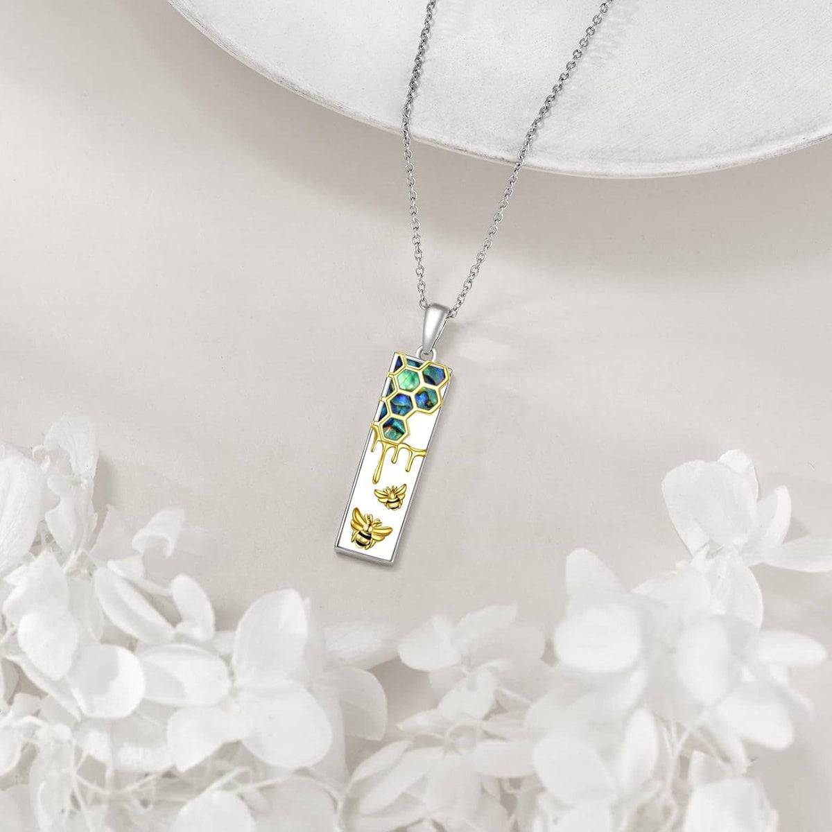 Rectangle pendant necklace on chain with blue hexagon enamel, gold drips, and bee charm