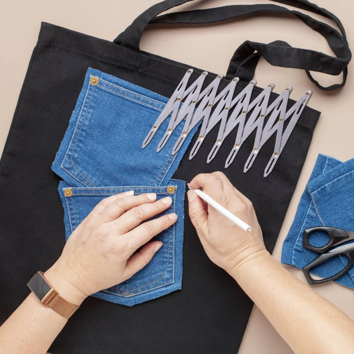 Aluminum quilting button guide placed on denim with hands aligning divider points