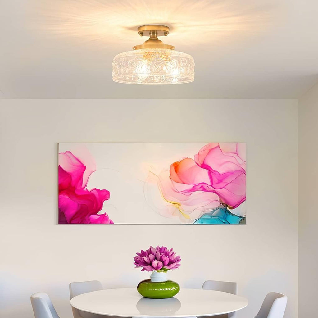 Semi-flush ceiling light with gold base and clear embossed globe glass shade