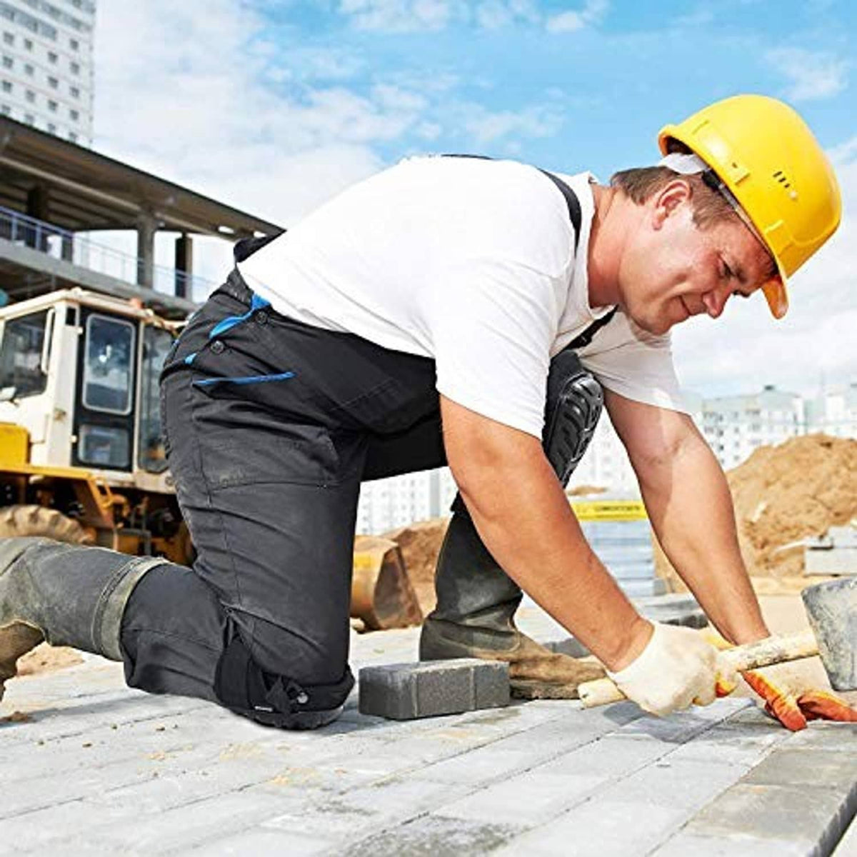 Black knee pads on a kneeling construction worker’s knees with adjustable straps