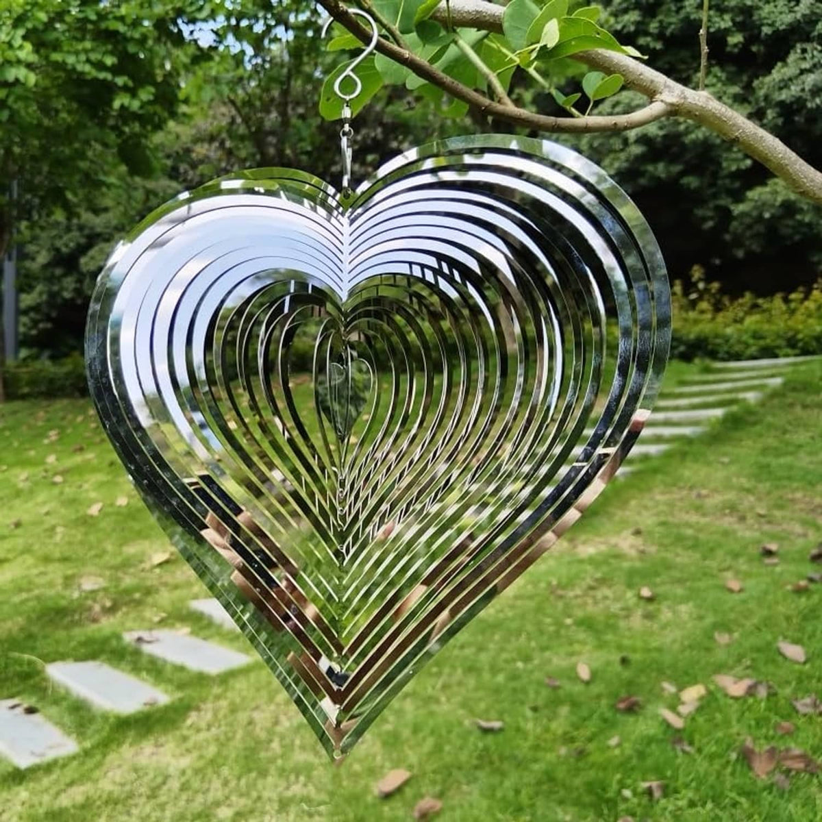 Heart-shaped hanging wind spinner with silver spiral rings and central disc