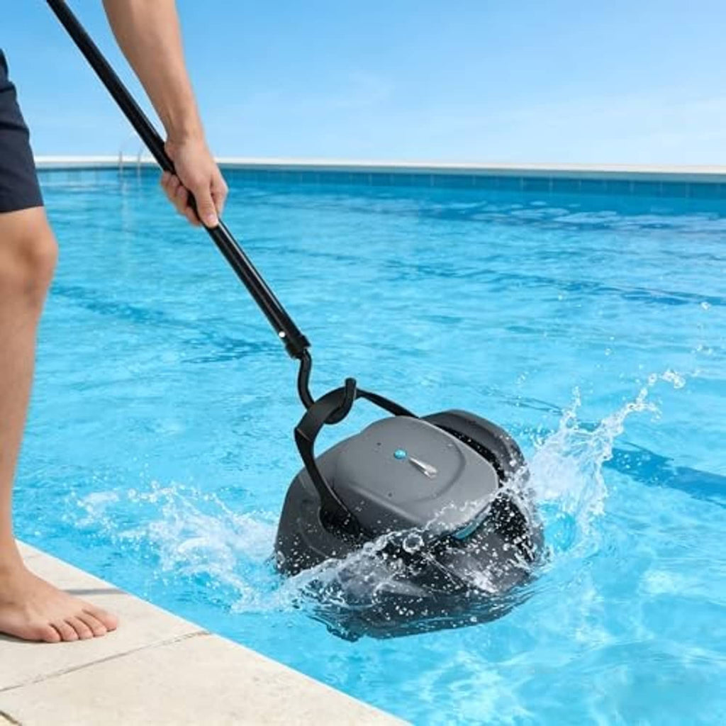 Black pool cleaner hook held by hand as water splashes around a robotic cleaner