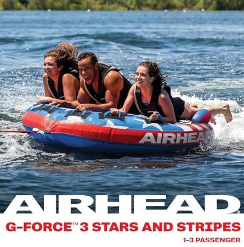 Inflatable towable tube carrying three riders on water, red and blue stars-and-stripes