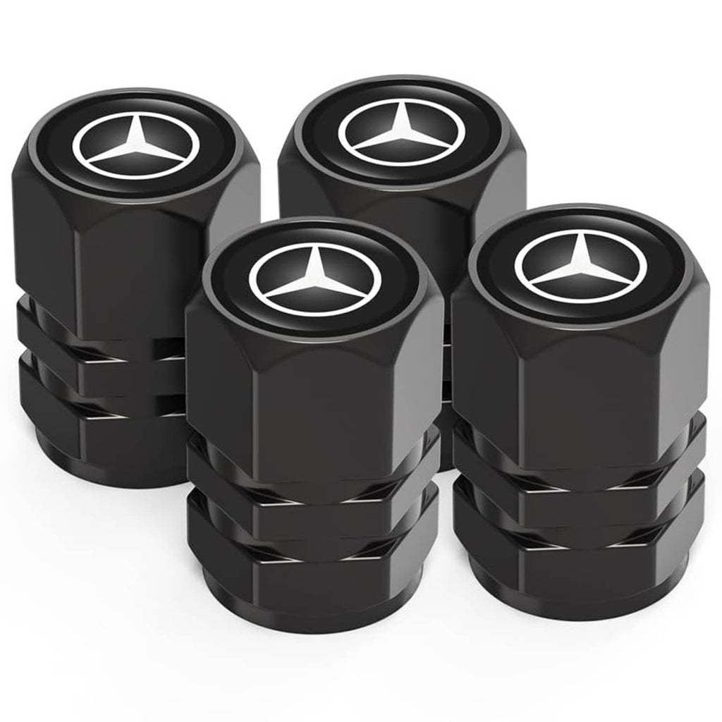 Four black metal tire valve stem caps with Mercedes-style logo, stacked close view