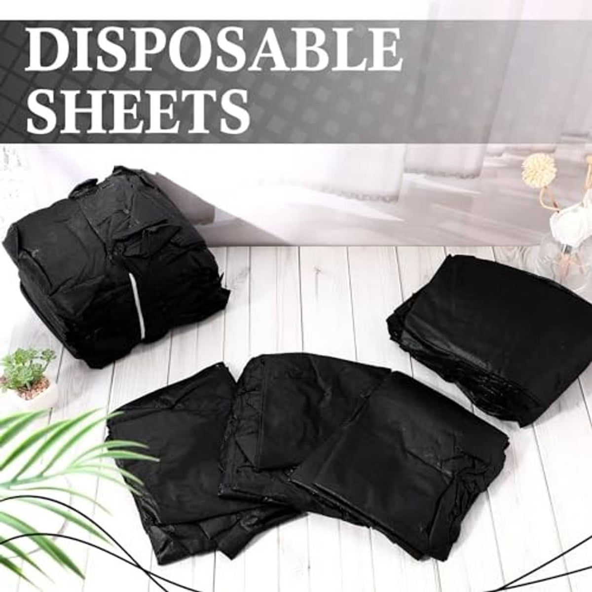 Multiple folded black disposable massage table sheets, packaged together