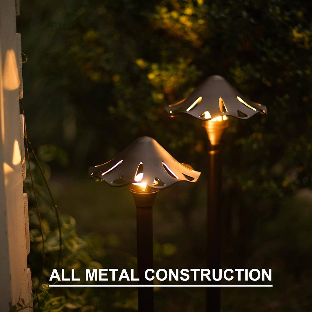 Two glowing low-voltage LED pathway lights with decorative perforated top plates