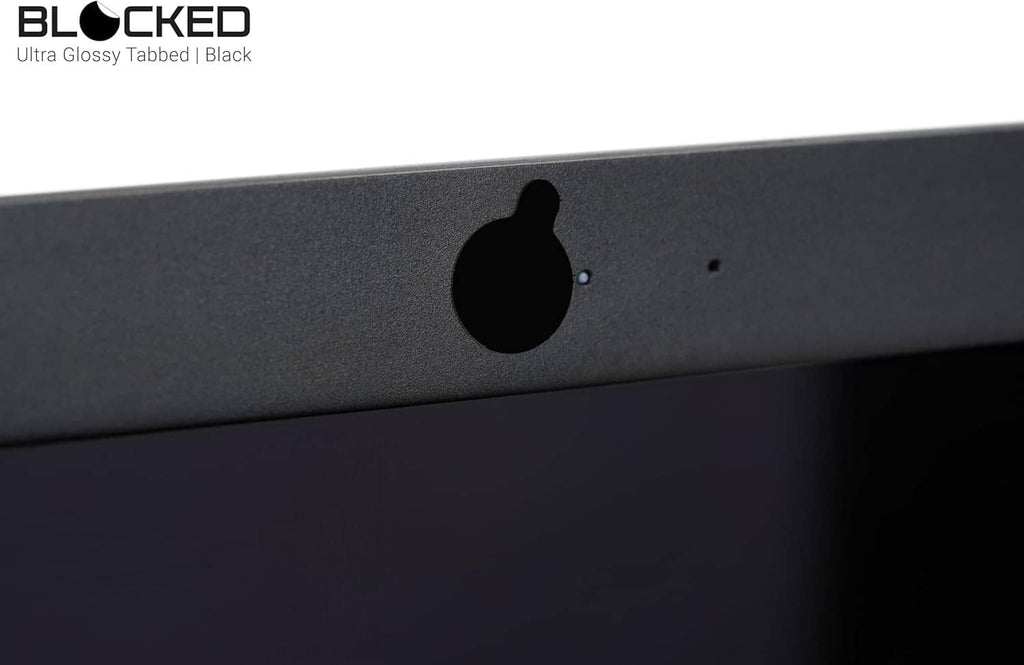 Black privacy cover sticker over a webcam opening on a dark device panel