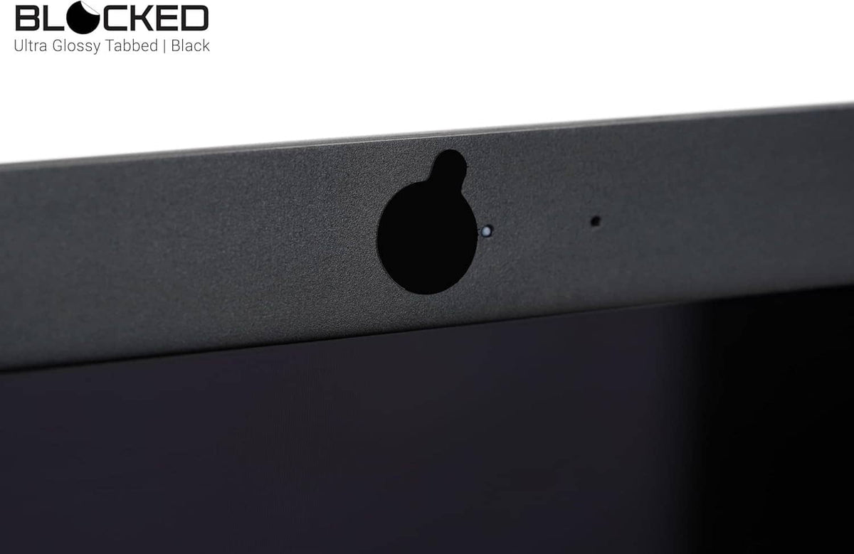 Black privacy cover sticker over a webcam opening on a dark device panel