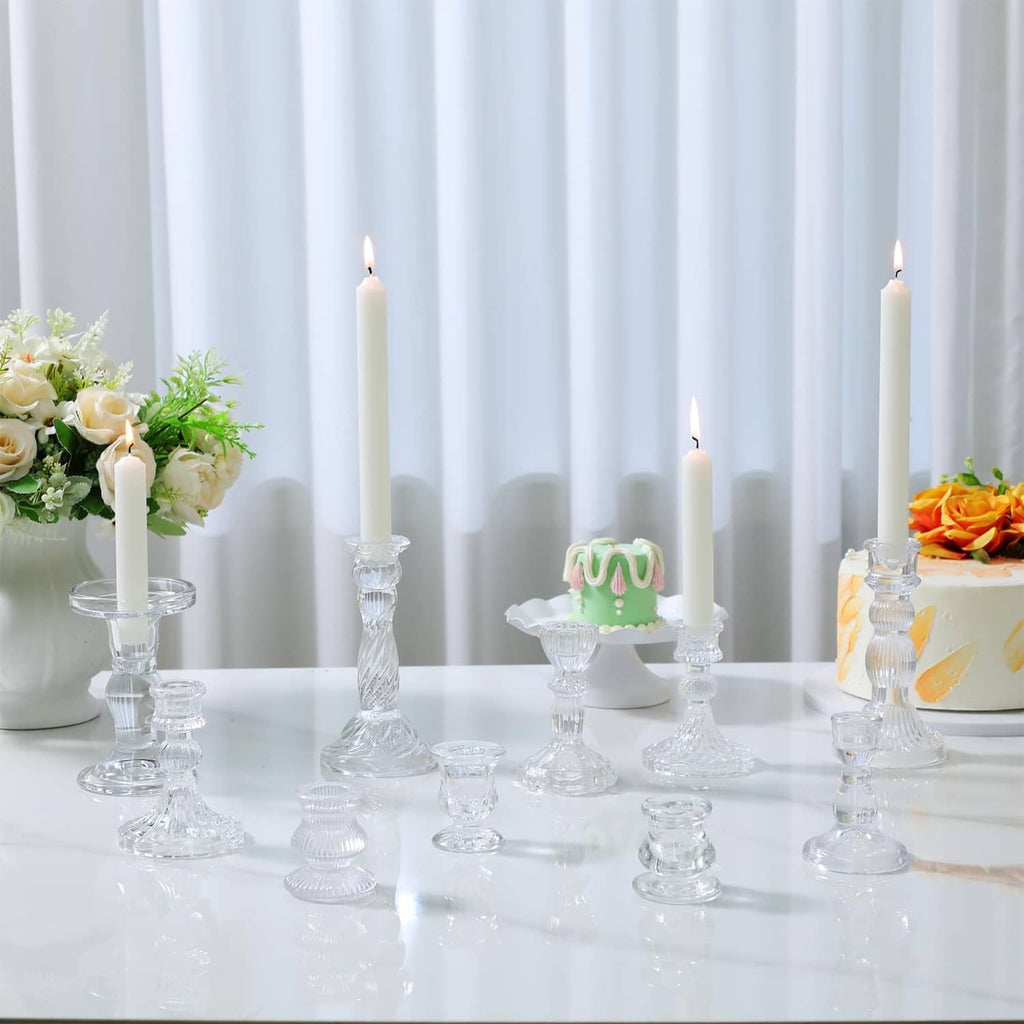 Clear glass taper candle holders with ribbed stems and fluted bases on table
