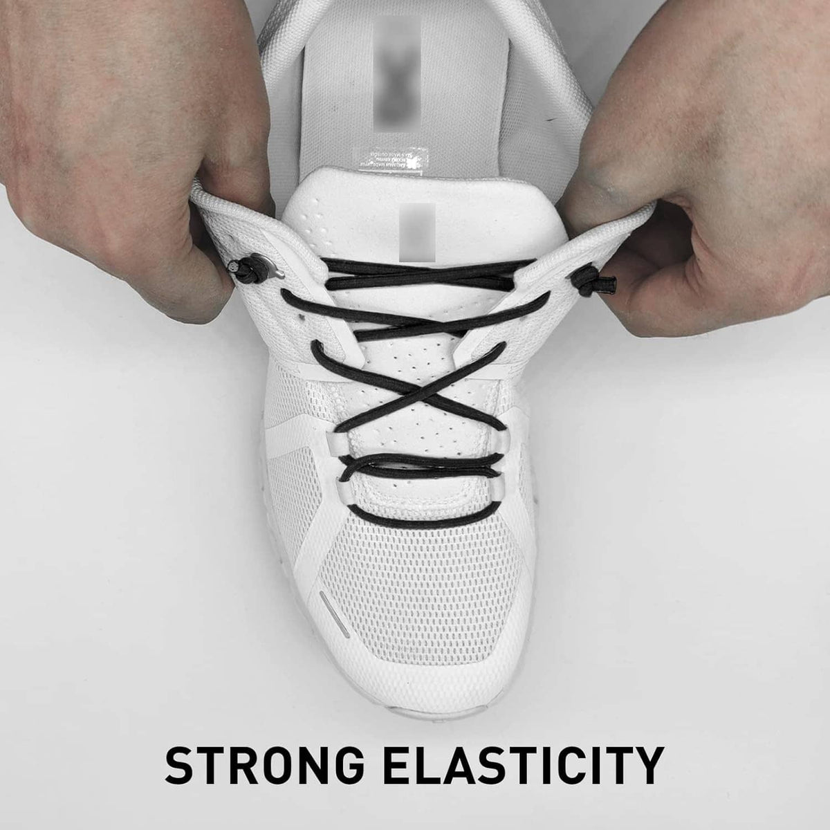 Elastic shoe laces being adjusted on a white sneaker with black lace loops