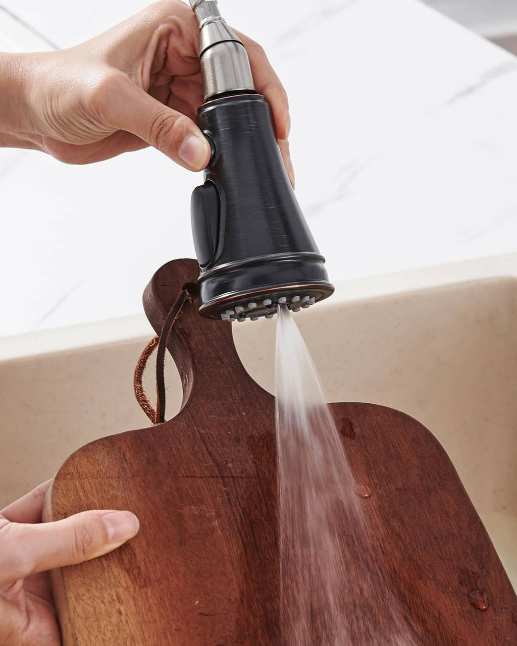 Oil rubbed bronze kitchen faucet sprayer head with water stream from the nozzle