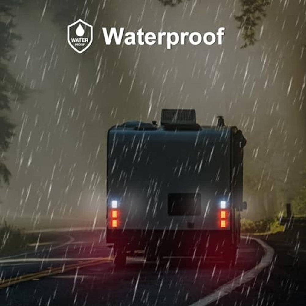 Truck rear with illuminated red and white LED trailer lights under rain