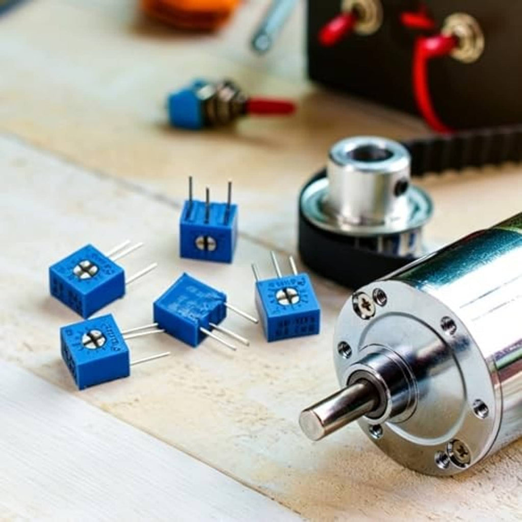 Blue trimmer potentiometers with three-pin leads on a wooden surface.