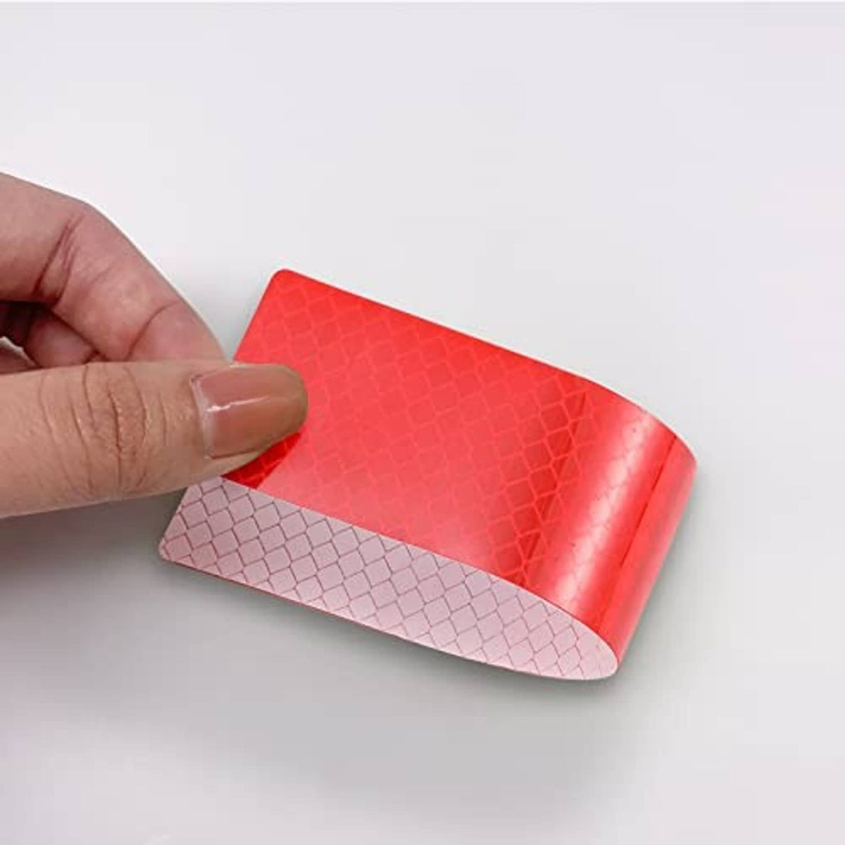 Close-up of red reflective anti-scratch sticker sheet with textured hex pattern