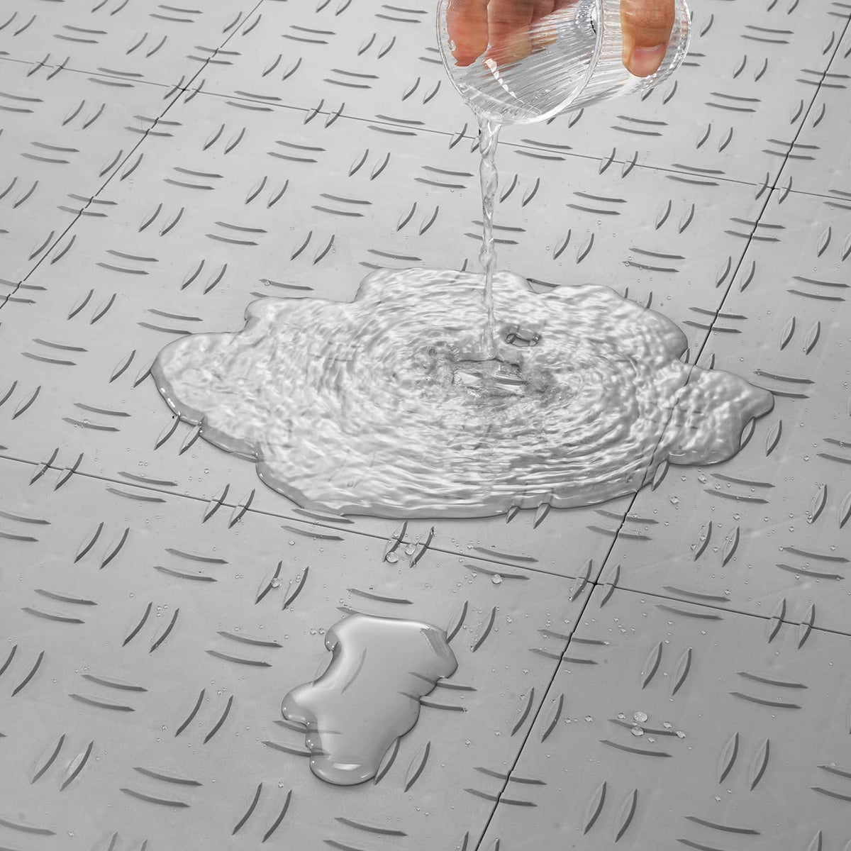 Silver interlocking garage floor tile with raised diamond texture and snap seams