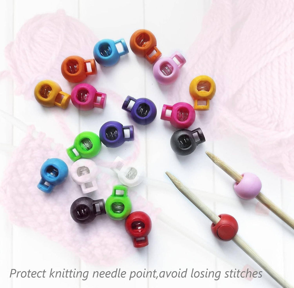 Assorted plastic knitting needle point stoppers in multiple colors, scattered.