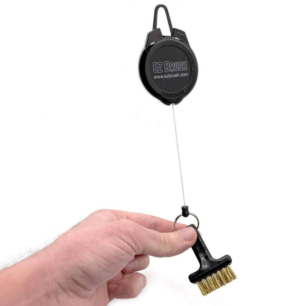 Retractable black EZ BRUSH golf club cleaning tool with gold bristle head on cord.