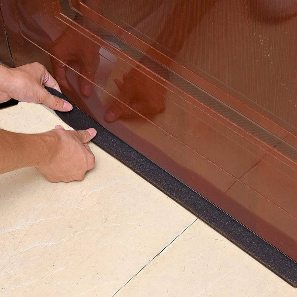 Black neoprene foam strip pressed along a baseboard and floor edge