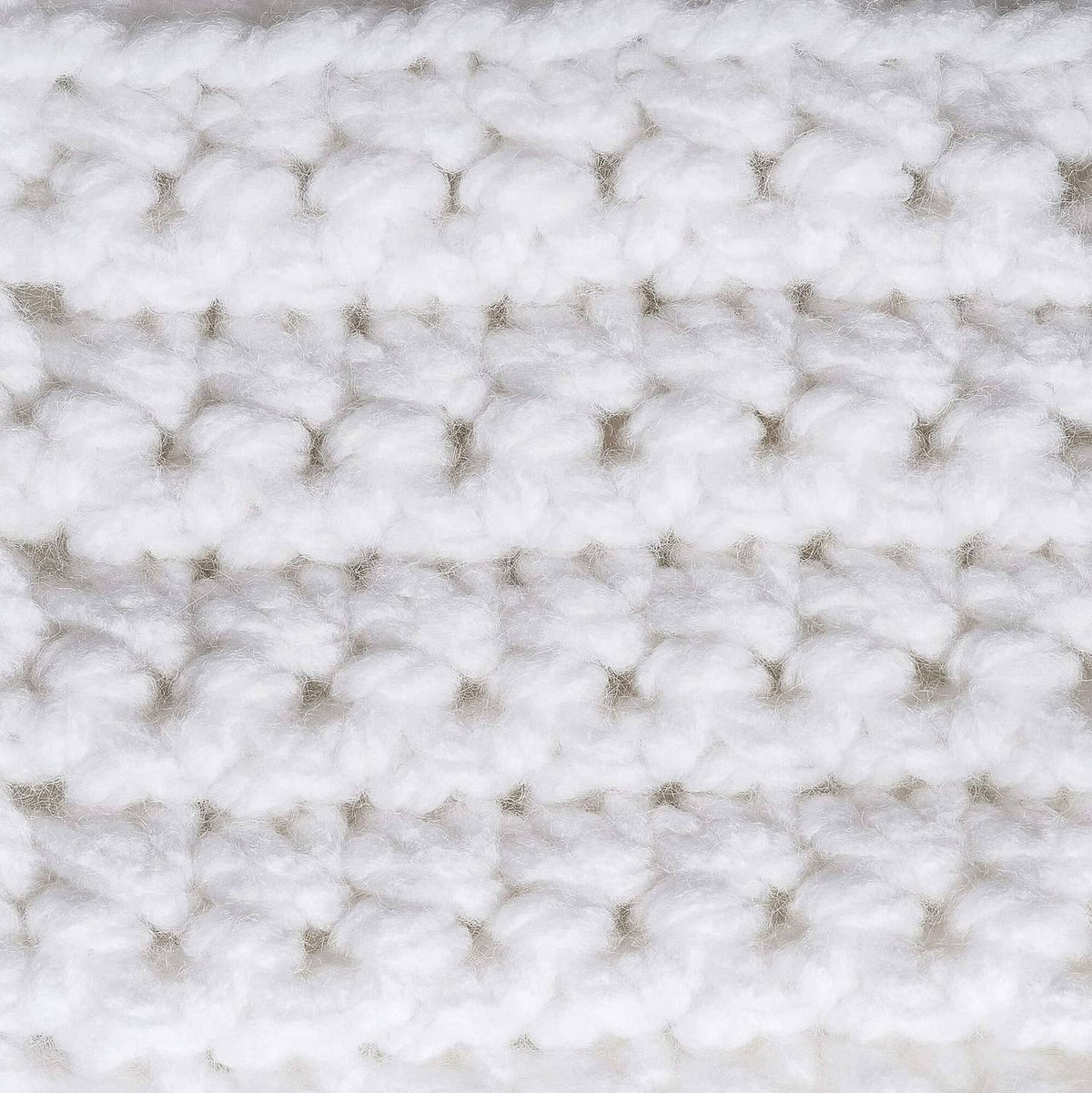 Close-up of white chunky acrylic yarn texture with nubby looped stitch pattern