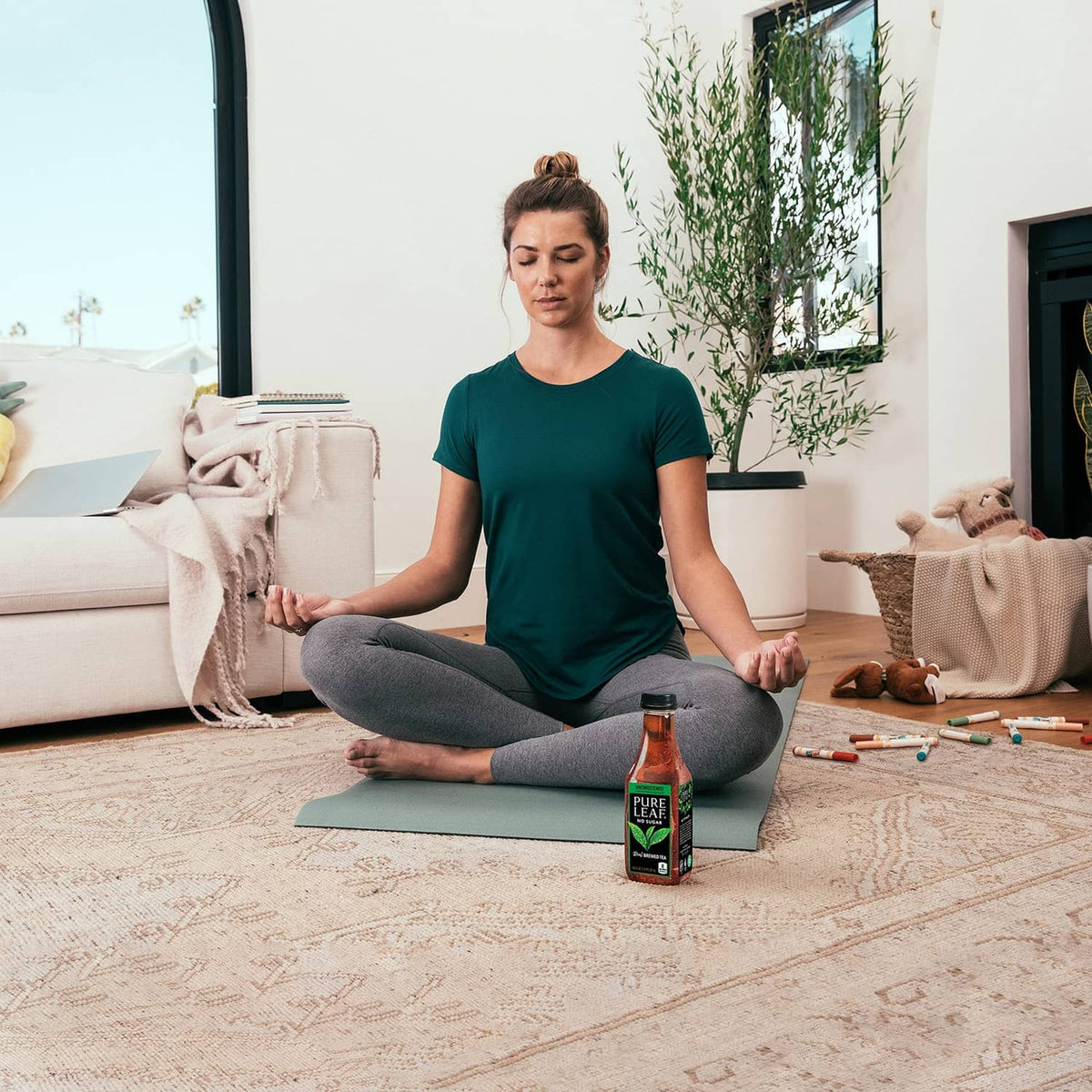 Pure Leaf unsweetened iced tea bottle near a person meditating