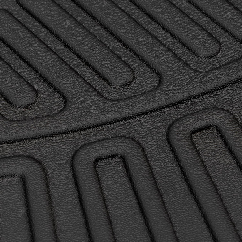 Black waterproof rubber floor mat with raised channels and gripping texture close-up