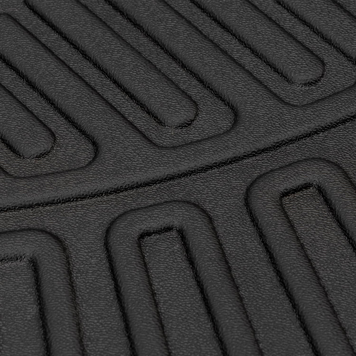 Black waterproof rubber floor mat with raised channels and gripping texture close-up