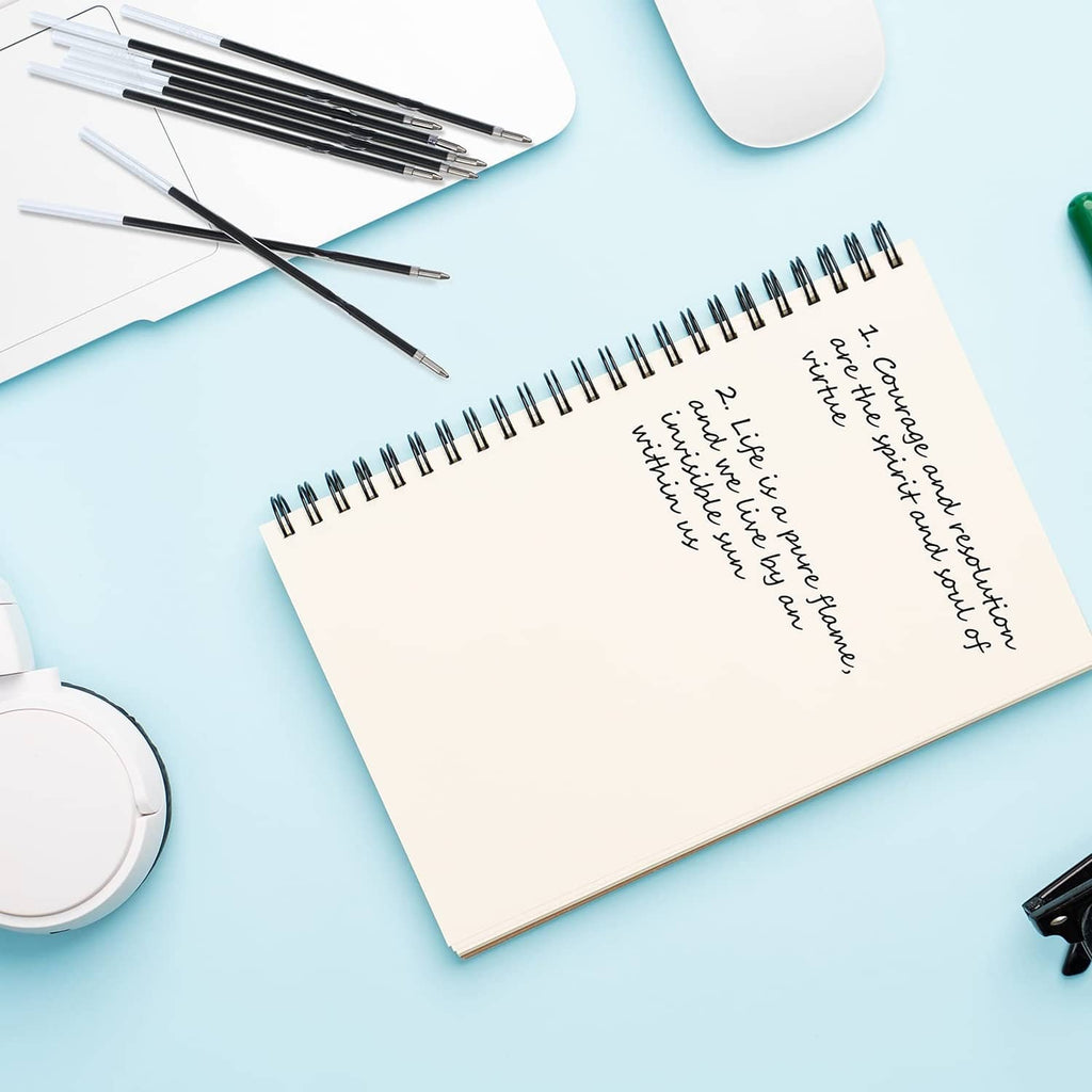 Pen refill set with 1 mm tips arranged near a notebook and stationery