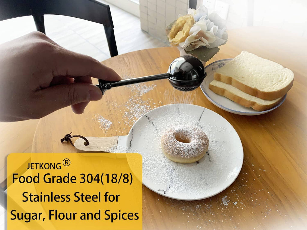 Black powdered sugar shaker duster with perforated cup over a bundt cake