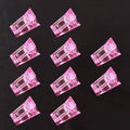Pink crystal nail tips clips, 10-piece set arranged on a flat surface