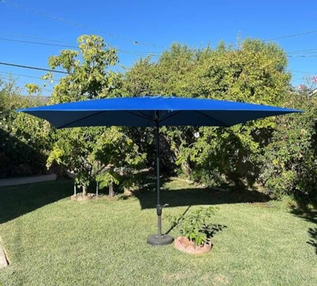 Blue rectangular umbrella canopy on a stand, open over the garden lawn with center button.