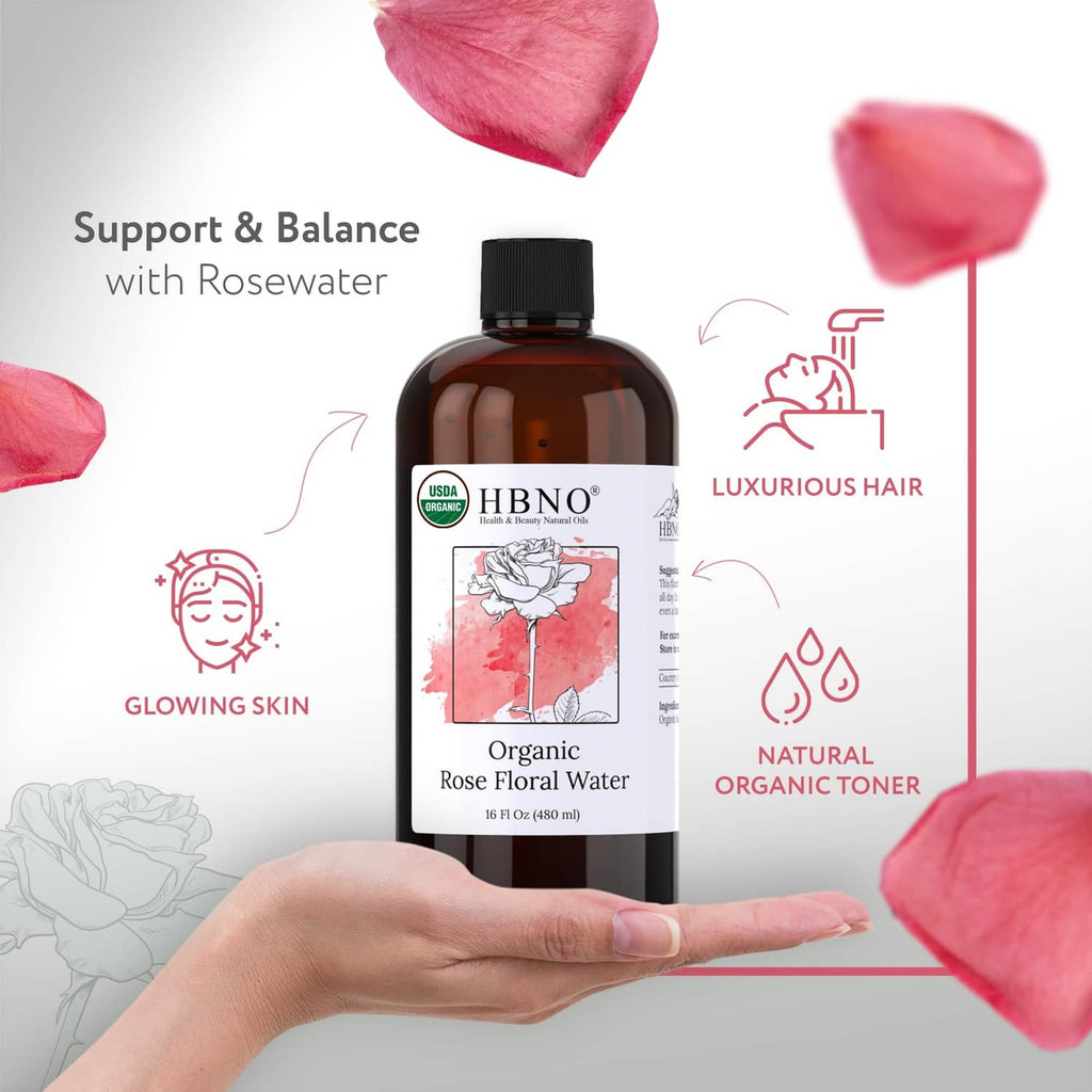 Amber rose water bottle with black cap, rose petals and hand holding it