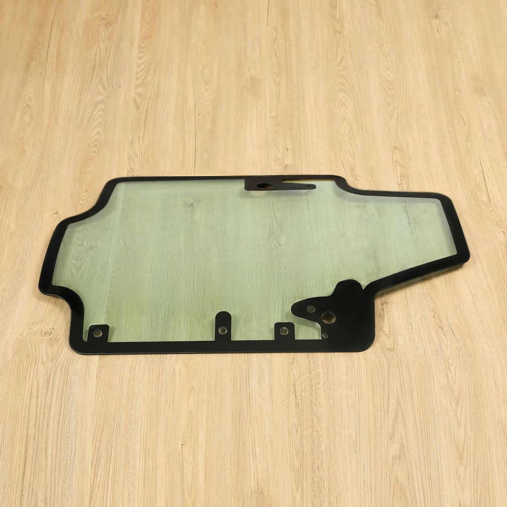 Skid steer door glass panel with black bottom frame and mounting tabs, tinted light green