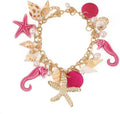 Colorful charm bracelet with seahorse, starfish, shells, faux pearls, and gold chain.