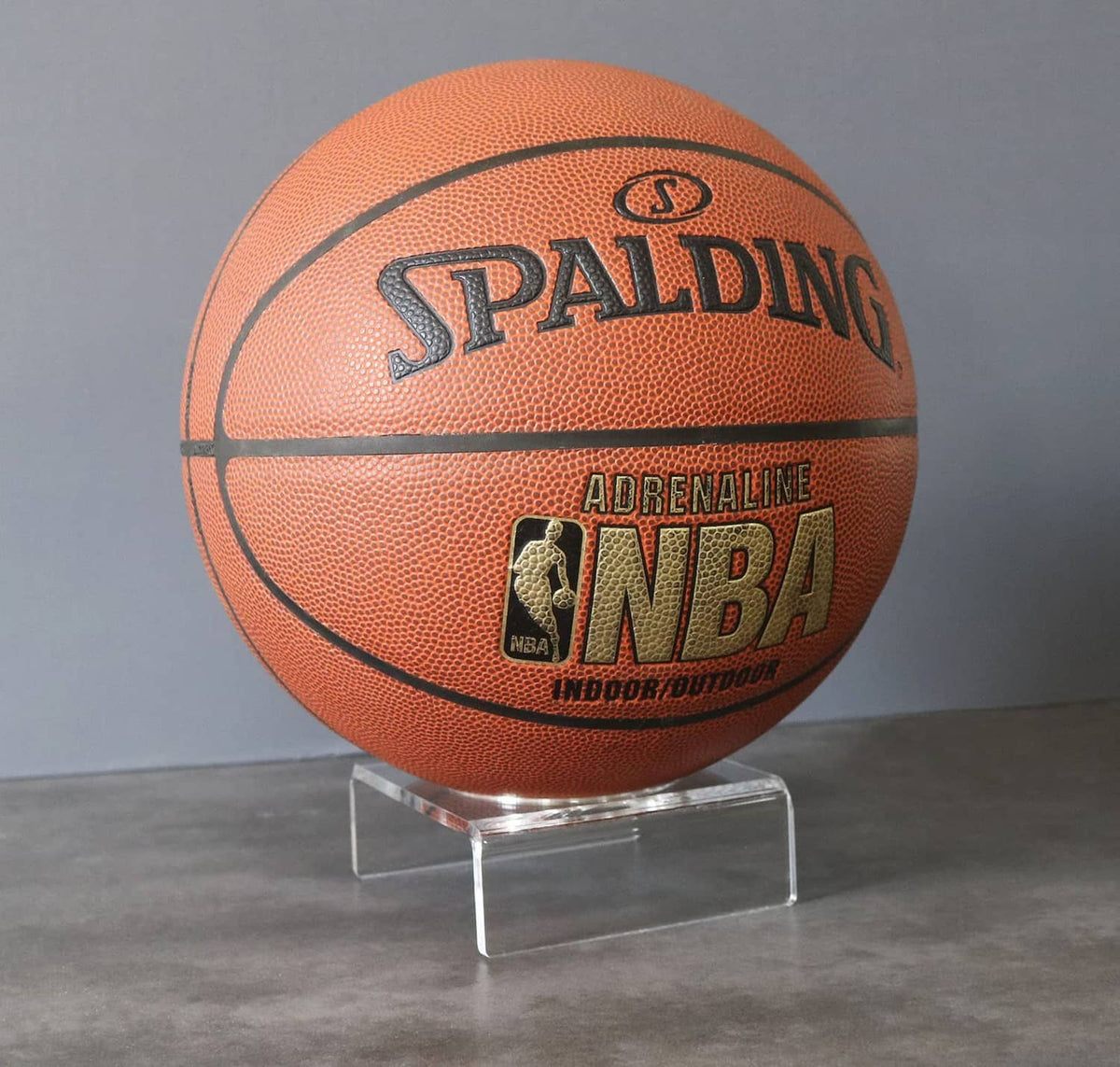 Clear acrylic basketball display stand with square base and curved ball support
