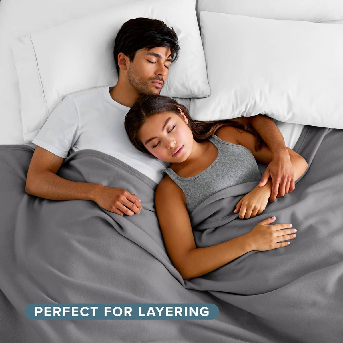 Gray blanket tucked around two people resting on a bed, smooth and cozy