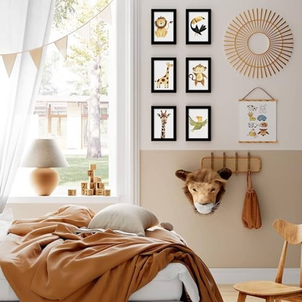 Black wall picture frames set with multiple small artworks and a hanging nursery banner