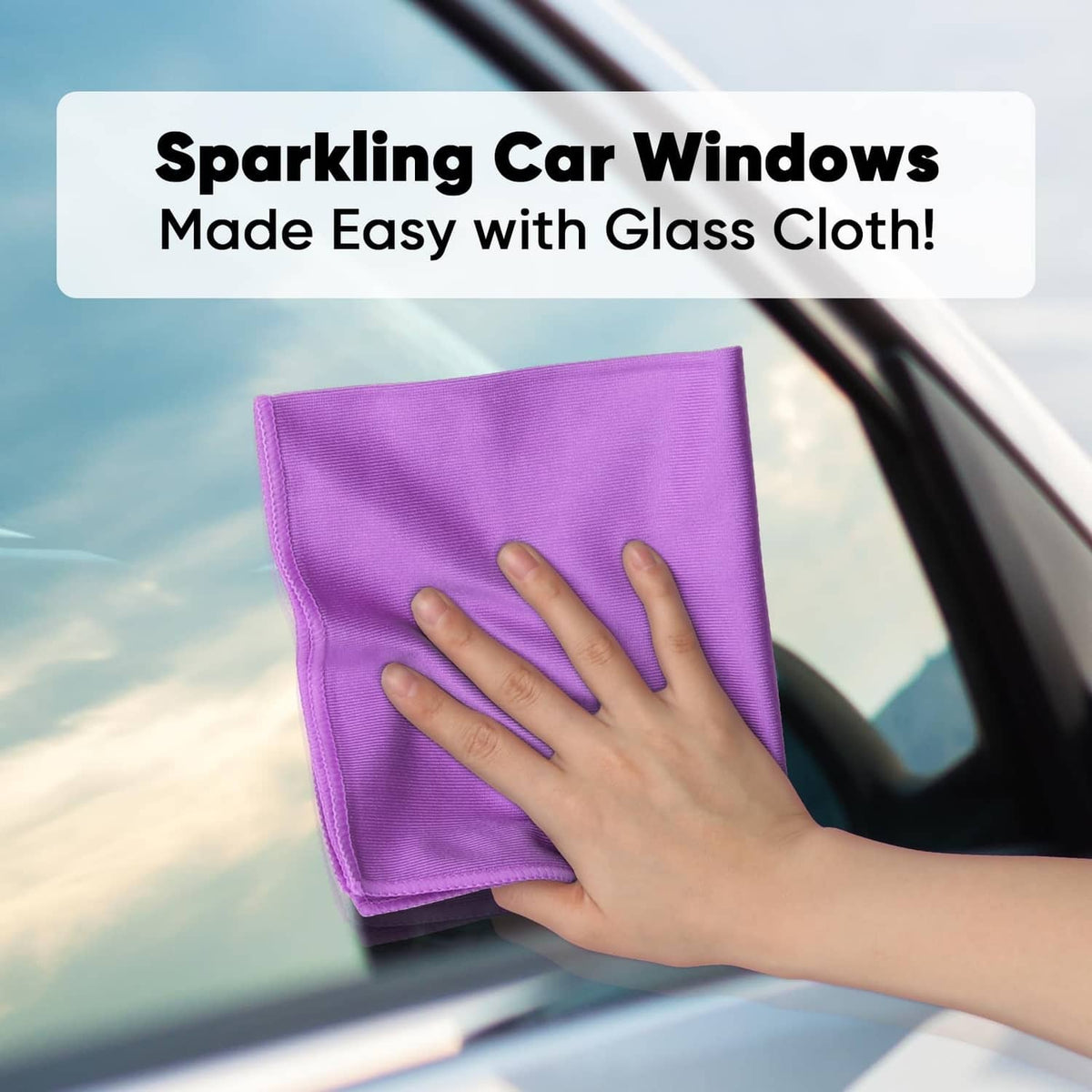 Purple microfiber cloth wiping a car window with a hand