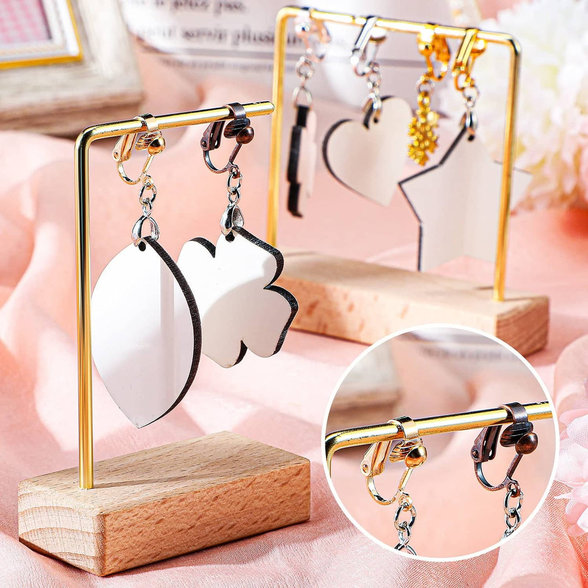 Gold-tone clip-on earrings with leaf-shaped black and gold dangle details