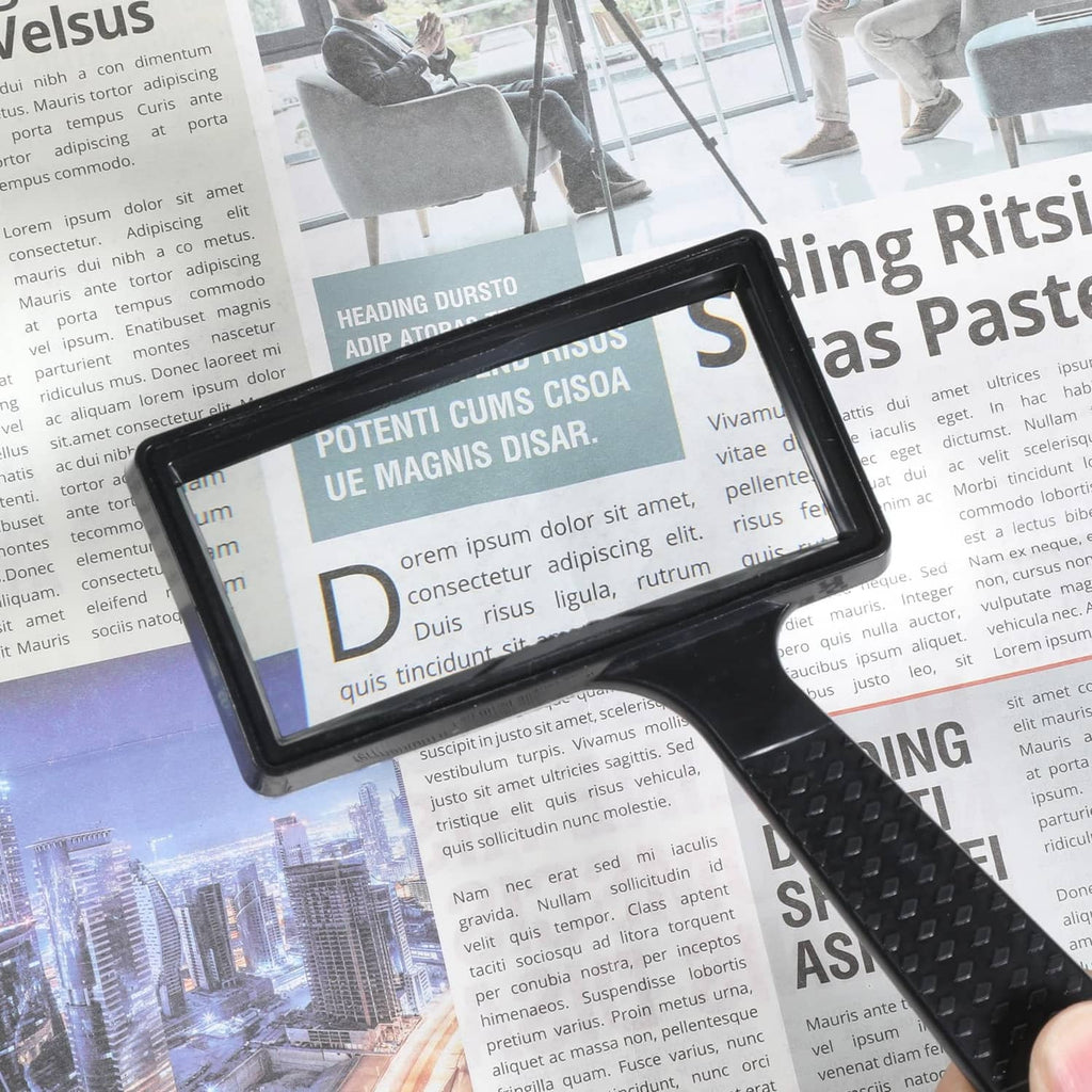 Black rectangular magnifier with clear lens and textured grip, handheld
