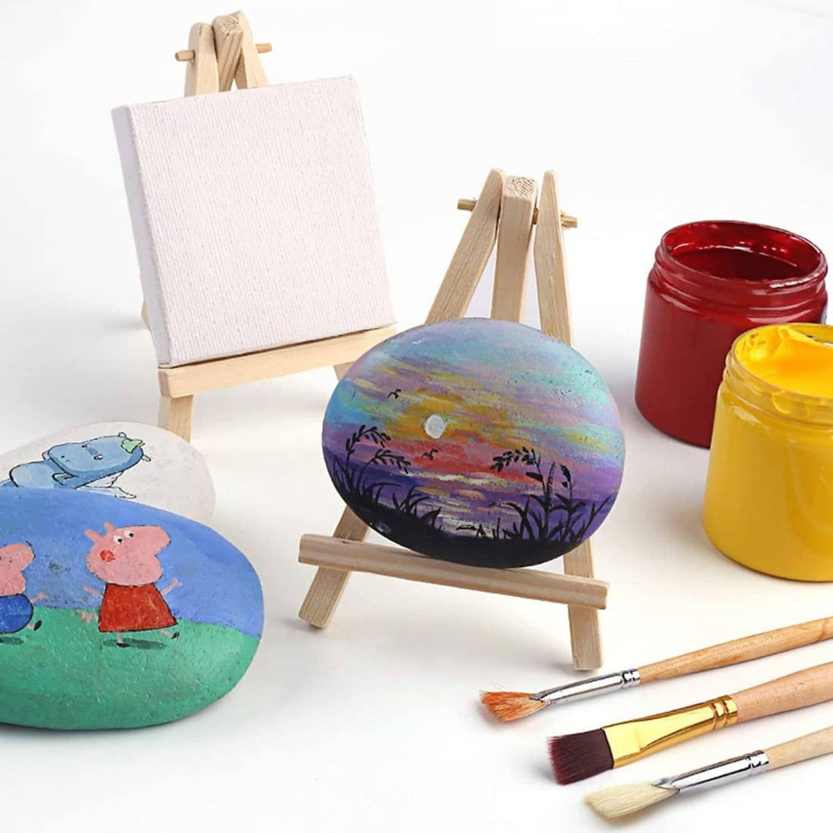 Small painted canvases on wooden easels with paint jars and paintbrushes