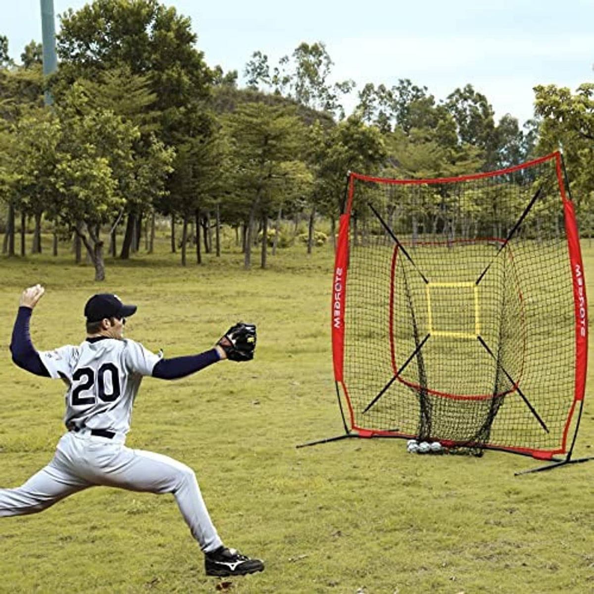 Red baseball practice net with yellow strike-zone target, viewed at angle with tripod base