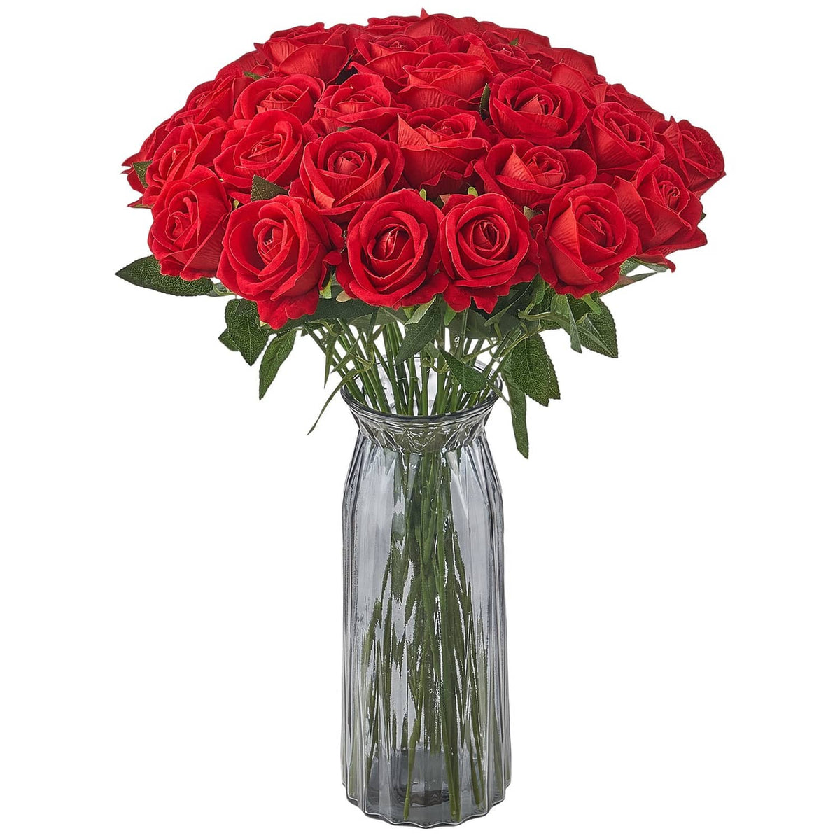 Red artificial rose bouquet with green leaves in clear glass vase