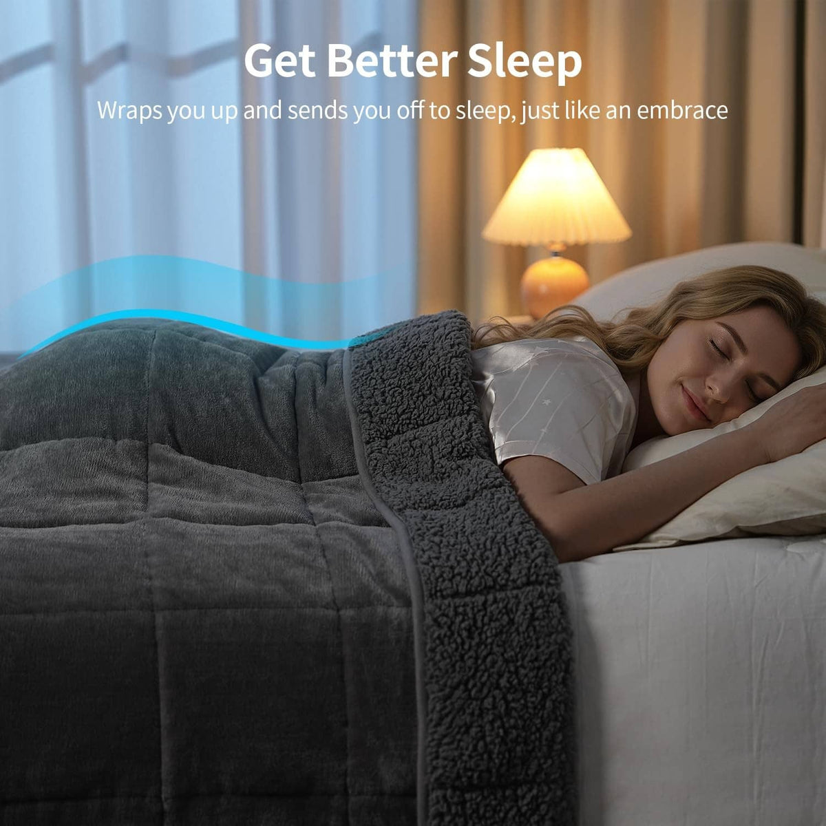 Grey weighted blanket tucked around a sleeper on a white bed