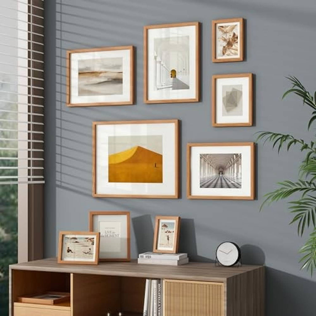 Natural cherry picture frames arranged on wall and shelf, each with clear glass