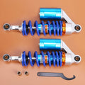 Pair of ATV rear air shocks absorbers with blue coil springs and silver mounting arms