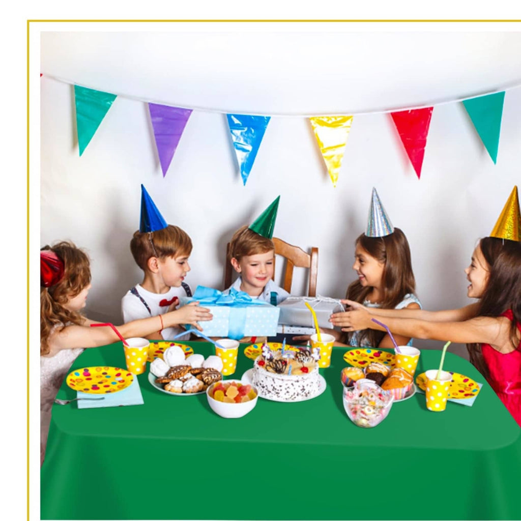 Green plastic tablecloth covering a table at a party setup