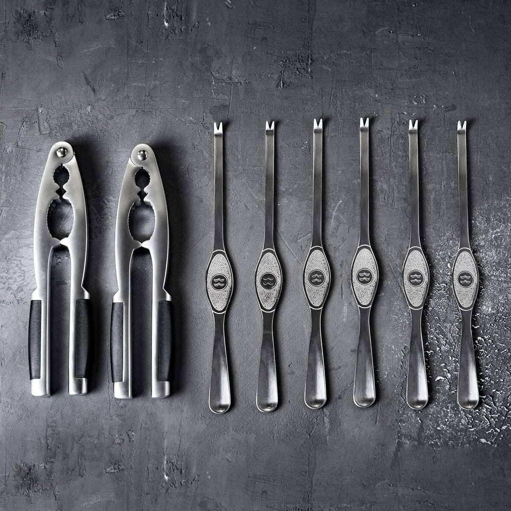 Row of metal seafood cracker forks and picks with textured grip handles
